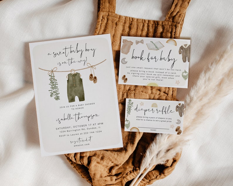 May include: A set of baby shower stationery in neutral tones. The main invitation card reads "a sweet baby boy is on the way!" and includes event details. Accompanying cards request books and diapers, with watercolour illustrations.