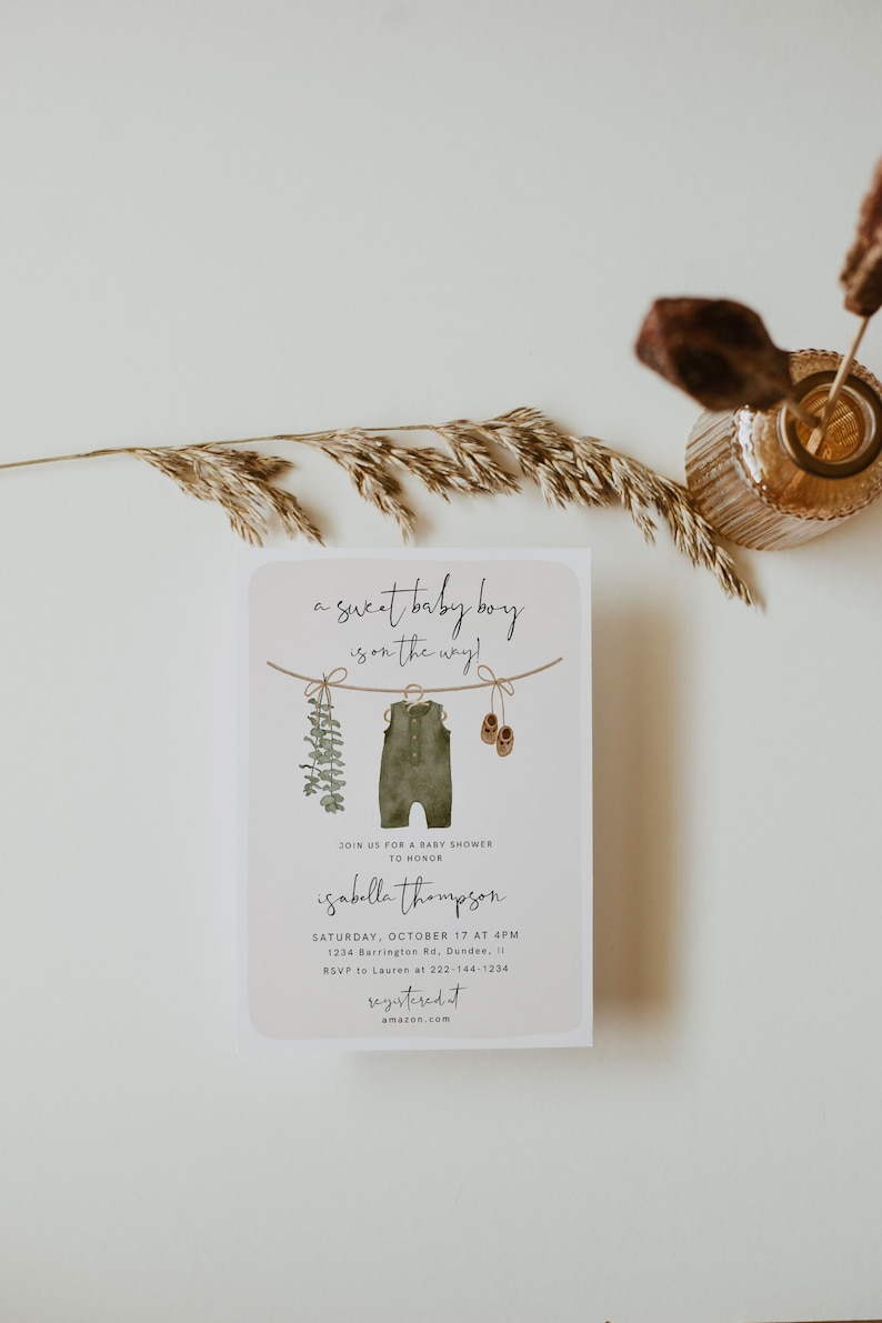 May include: Baby shower invitation with the text "a sweet baby boy is on the way!" The invitation features watercolor illustrations of a onesie, baby shoes, and greenery. The invitation includes the name Isabella Thompson, date, time, and location.