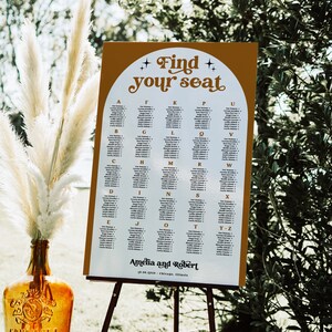 May include: A white seating chart with a brown background and gold stars. The chart is titled "Find your seat" and lists names in alphabetical order. The bottom of the chart reads "Amelia and Robert 19.08.2010 Chicago, Illinois."