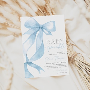 May include: A baby shower invitation card with a light blue watercolor bow and ribbons. The card reads "BABY sprinkle" and includes event details. The invitation is set against a neutral background with dried grasses.