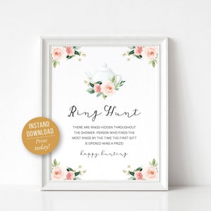 May include: A printable sign for a bridal shower ring hunt game. The sign features a white teapot with pink and white flowers and the text "Ring Hunt" in a cursive font. The text below the title reads "There are rings hidden throughout the shower, person who finds the most rings by the time the first gift is opened wins a prize! Happy hunting."