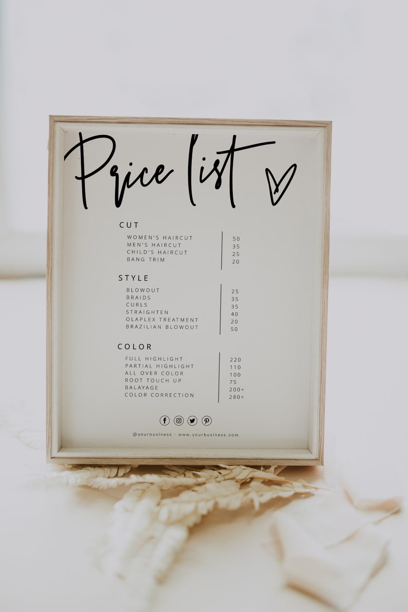 May include: A white framed sign with a black handwritten price list for hair salon services. The sign lists prices for haircuts, styling, and color services. The sign also includes social media icons and a website address.