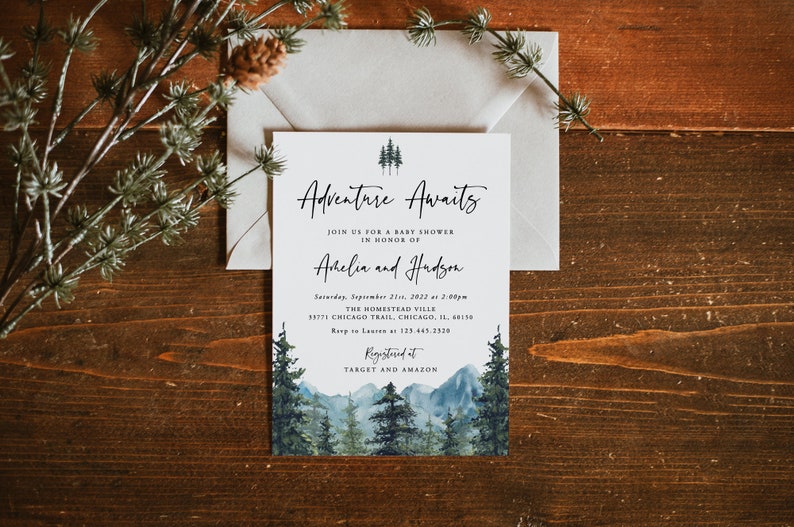 Pu&ograve; includere: Un biglietto bianco con testo nero che annuncia una baby shower per Arhelia e Hudson. Il testo recita "Adventure Awaits" e include la data, l'ora e il luogo dell'evento. Il biglietto &egrave; decorato con un'illustrazione ad acquerello di una catena montuosa e pini.