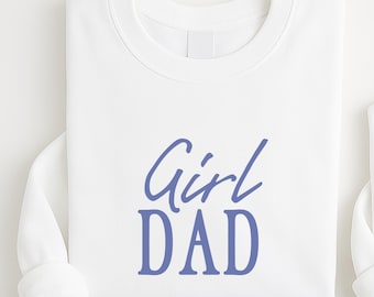 May include: Two white long-sleeved sweatshirts. One has the words "Girl DAD" in blue script. The other has blue bow illustrations and the words "DADDY'S GIRL". The sweatshirts are likely for a parent and child.