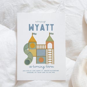 May include: A birthday party invitation featuring a playground design. The text reads "Let's play! WYATT is turning three." The invitation also includes the date, time, location, and RSVP details.