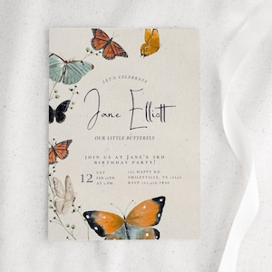 以下が含まれることがあります： ベージュ色の背景に、オレンジ、青、黒色の水彩画の蝶が描かれた長方形の招待状。テキストには「Let's Celebrate Jane Elliott, Our Little Butterfly」と書かれており、パーティーの詳細が含まれています。