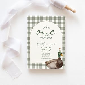 May include: A green and white gingham patterned invitation with a duck illustration. The text reads "Jack is one Lucky Duck. Waddle on over! Saturday Nov 12th at 3 PM. The Taylor's 123 Waddle Way Ducktown, FL RSVP 123.456.7890"