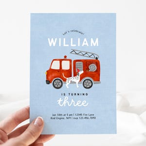 May include: A blue invitation card with a red fire truck and a dalmatian dog. The text on the card reads "Let's celebrate! William is turning three. Jan 10th at 5 pm | 12345 Fire Lane Red Engine, NM | rsvp 123.456.7890"
