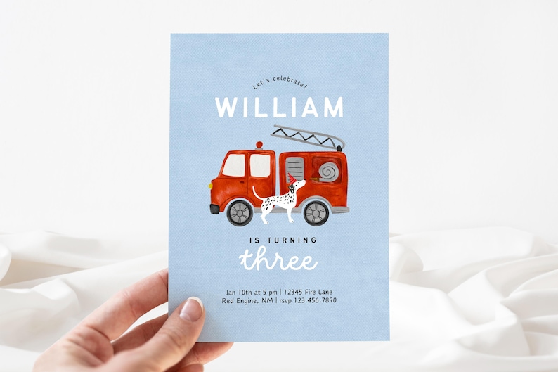 May include: A blue invitation card with a red fire truck and a dalmatian dog. The text on the card reads "Let's celebrate! William is turning three. Jan 10th at 5 pm | 12345 Fire Lane Red Engine, NM | rsvp 123.456.7890"