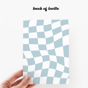 Op de afbeelding: De achterkant van een witte uitnodigingskaart met een blauw-wit geruit patroon. De tekst "back of invite" is op de kaart gedrukt.