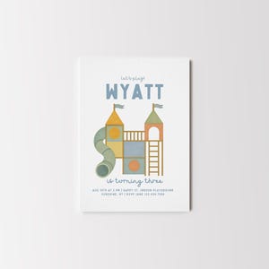 May include: A white invitation card with a playground illustration. The card features the name "WYATT" in blue, the text "is turning three", and event details. The playground design includes a slide, towers, and ladders.
