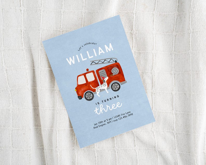 May include: A blue and white birthday invitation with a red fire truck and a dalmatian dog. The invitation says "Let's celebrate! William is turning three." and includes the date, time, and location of the party.