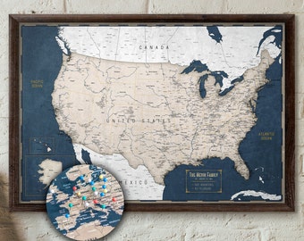 May include: A framed United States map with a dark wood frame. The map is beige with navy blue accents and includes a smaller, circular map of Europe with pins. The text "The McVin Family" is visible.
