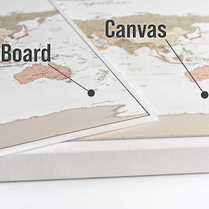 May include: Two world maps, one on a pin board and one on canvas. The pin board map is on top of the canvas map. The text "Pin Board" is visible on the top map and the text "Canvas" is visible on the bottom map.