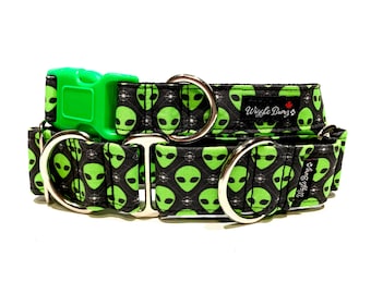 May include: A green and black dog collar with a silver buckle and two silver D-rings. The collar features a repeating pattern of green alien faces with black eyes and a white background. The collar is labelled "Wiggle Bungo".