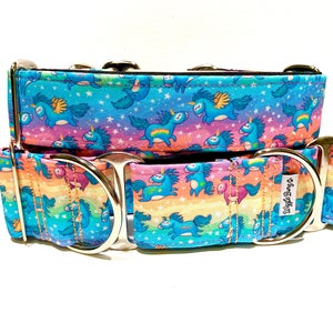 Puede incluir: Un collar para perro azul y rosa con un patrón de arcoíris y unicornio. El collar tiene herrajes metálicos plateados y el texto "Shrug Off" es visible en el collar.