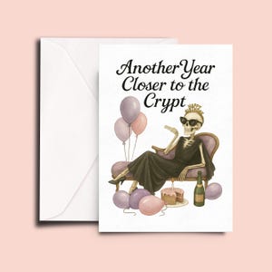 May include: A humorous birthday card featuring a skeleton wearing sunglasses and a crown, lounging on a chaise lounge. The card includes the text "Another Year Closer to the Crypt" with balloons, cake, and a champagne bottle.