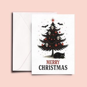 K&ouml;nnte beinhalten: Weihnachtskarte mit einem schwarzen Weihnachtsbaum, verziert mit Totenkopf-Ornamenten und roten Kugeln. Eine schwarze Katze liegt am Fu&szlig;e des Baumes. Die Worte "MERRY CHRISTMAS" sind rot und schwarz gedruckt. Ein wei&szlig;er Umschlag ist enthalten.