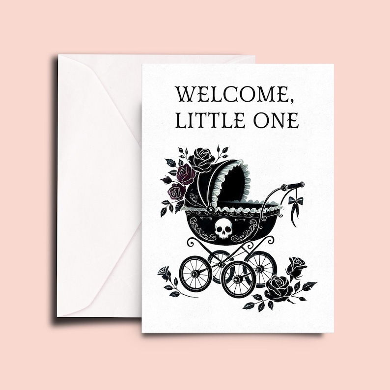May include: A white greeting card and matching envelope featuring the text WELCOME, LITTLE ONE in black. The card displays a black baby carriage illustration adorned with a skull motif, dark roses, and a small bow, set against a plain white background.
