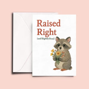 May include: A greeting card with a raccoon holding a bouquet of yellow flowers. The card reads "Raised Right (and Slightly Feral)"