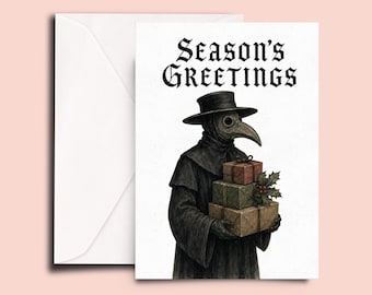 May include: A white greeting card with a black and white illustration of a plague doctor wearing a wide-brimmed hat and bird-like mask. The figure holds a stack of three wrapped gifts adorned with holly. The text Season's Greetings is printed above.