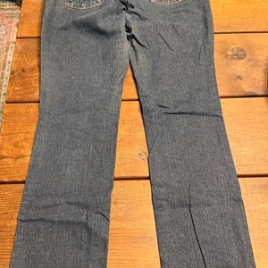 以下が含まれることがあります： 手書き風の「Welcome to our home」の文字が入った素朴な木製サイン。使い古したような仕上がりで、シンプルで魅力的なデザインは、玄関やポーチに最適です。