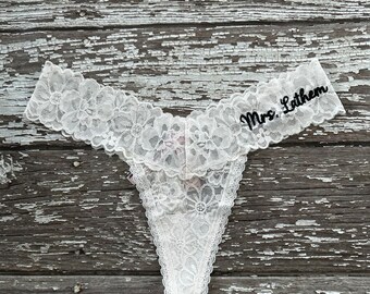 May include: White lace lingerie with a black embroidered "Mrs. Latham" detail.