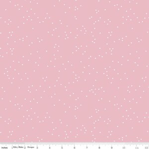 May include: A pink fabric with a white confetti pattern. The fabric is a solid pink color with small white squares scattered throughout.