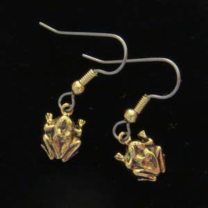 Puede incluir: Un par de pendientes de rana de oro con ganchos de plata. Las ranas están mirando hacia adelante con las patas extendidas.