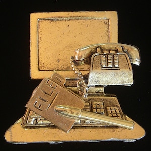 May include: Gold-toned metal desktop computer figurine with a phone, a file folder, and a pen. The computer screen is blank.