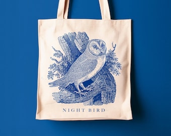 May include: A white canvas tote bag with a blue ink illustration of an owl perched on a branch. The text "NIGHT BIRD" is printed in blue at the bottom of the bag.