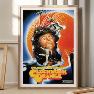May include: Framed poster for Stanley Kubrick's "A Clockwork Orange." The artwork features a man with a headpiece, set against an orange and blue backdrop. The film's title is in orange and yellow. The poster is in a wooden frame.