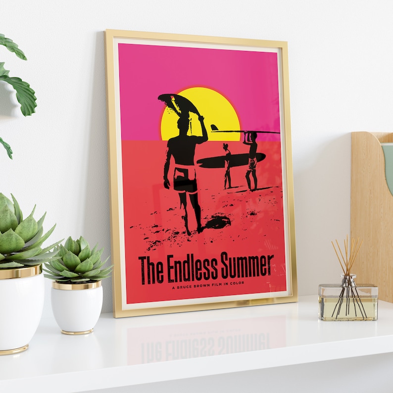 May include: A vintage movie poster for "The Endless Summer", a Bruce Brown film in color. The poster features a silhouette of a surfer carrying a surfboard against a pink and yellow sunset.