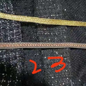 May include: Four different types of trim, including gold, brown, and black, are shown on a black fabric background. The trim is labeled with numbers 1 through 4.