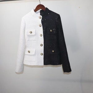 May include: A white and black tweed jacket with gold buttons. The left side of the jacket is white and the right side is black.