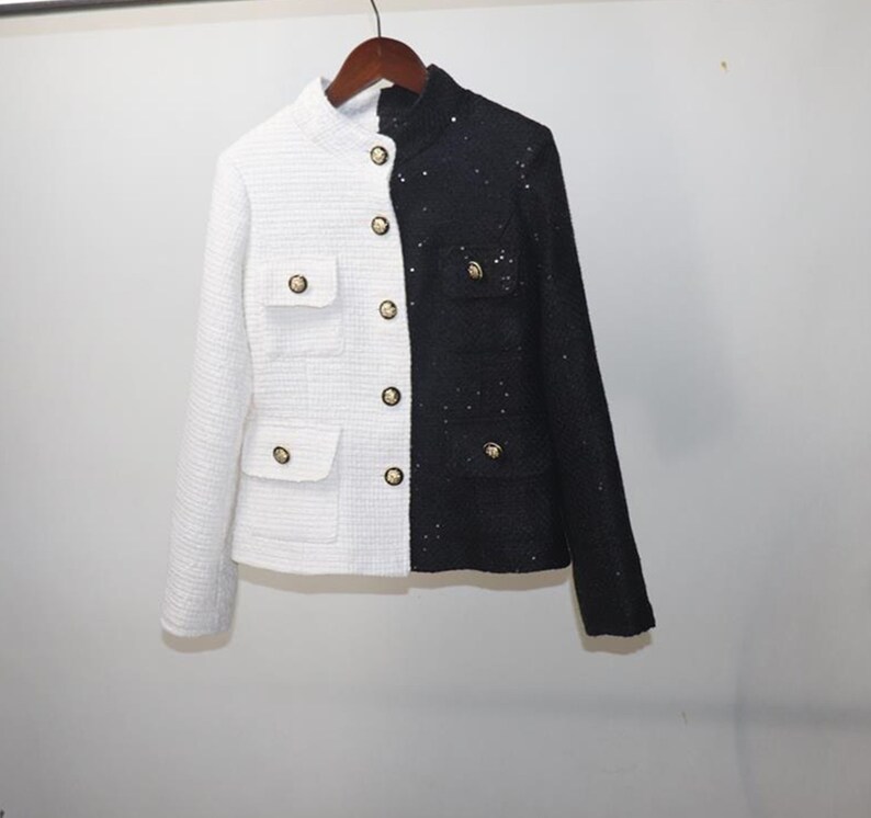 May include: A white and black tweed jacket with gold buttons. The left side of the jacket is white and the right side is black.