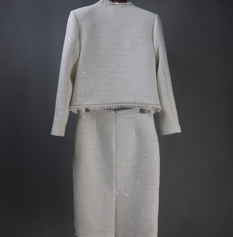Back view of custom white formal suit with sequinned jacket and skirt, featuring pearl and chain trim – handmade outfit for weddings, graduations, or formal events