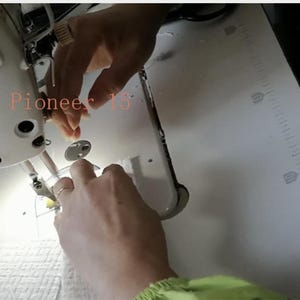 May include: A close-up of a sewing machine with the brand name "JUKI" visible. The image shows hands working with the machine, likely sewing fabric. The text "Fashion Pioneer 13" is also visible.
