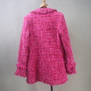 Back view of the handmade hot pink tweed blazer highlighting its structured fit, clean seam lines, and raw-edge fringe hem.