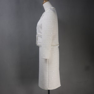 Side view of custom-made white sequin jacket and skirt set with pearl and chain trim – sophisticated women's formalwear for graduation, dinner, or special occasions
