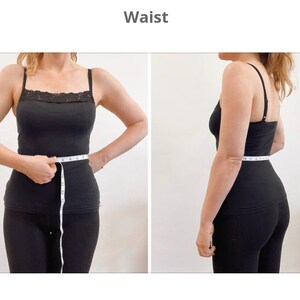 Op de afbeelding: Een persoon in zwarte kleding meet zijn taille met een wit meetlint. Het meetlint geeft 28 inch aan.