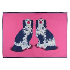 May include: Two blue and white porcelain dogs with pink noses and black eyes sitting on a pink background.
