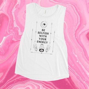 Puede incluir: Camiseta blanca sin mangas de tirantes con un estampado gráfico negro que dice "Sé egoísta con tu energía". El gráfico también incluye una luna creciente, un ojo y una botella con un ojo dentro.