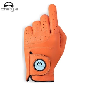 Puede incluir: Guante de golf naranja con la palabra "onstyle" impresa en la muñeca. El guante es de cuero y tiene pequeñas perforaciones en la palma y los dedos. El dedo índice está extendido hacia arriba.