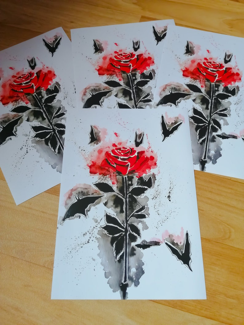 Puede incluir: Cuatro impresiones de acuarela de una rosa roja con murci&eacute;lagos negros volando a su alrededor. La rosa est&aacute; pintada en un estilo realista con una lavada de acuarela.