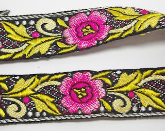 Puede incluir: Borde de tela negro con un diseño floral. El borde presenta flores rosas con acentos amarillos y blancos sobre un fondo negro.