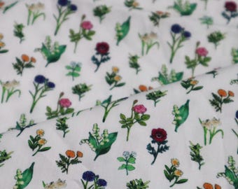 Tela de algodón con estampado floral blanco, ideal para acolchado.
