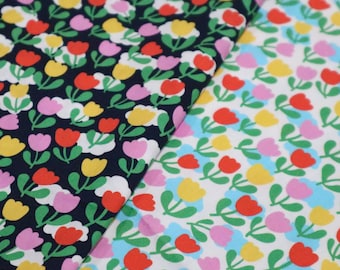 Tela de algodón con estampado floral colorido, ideal para acolchado.