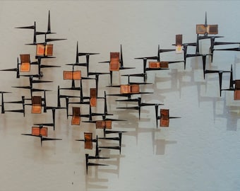 May include: A wall sculpture made of metal and wood. The sculpture is composed of a series of geometric shapes, with a variety of colors and textures. The sculpture is a modern and abstract design.