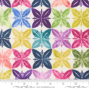 May include: A fabric with a repeating pattern of colorful, stylized floral shapes. The flowers are in shades of pink, purple, blue, green, and yellow, set against a cream background. The fabric has a ruler along the bottom with the Moda Fabrics logo.